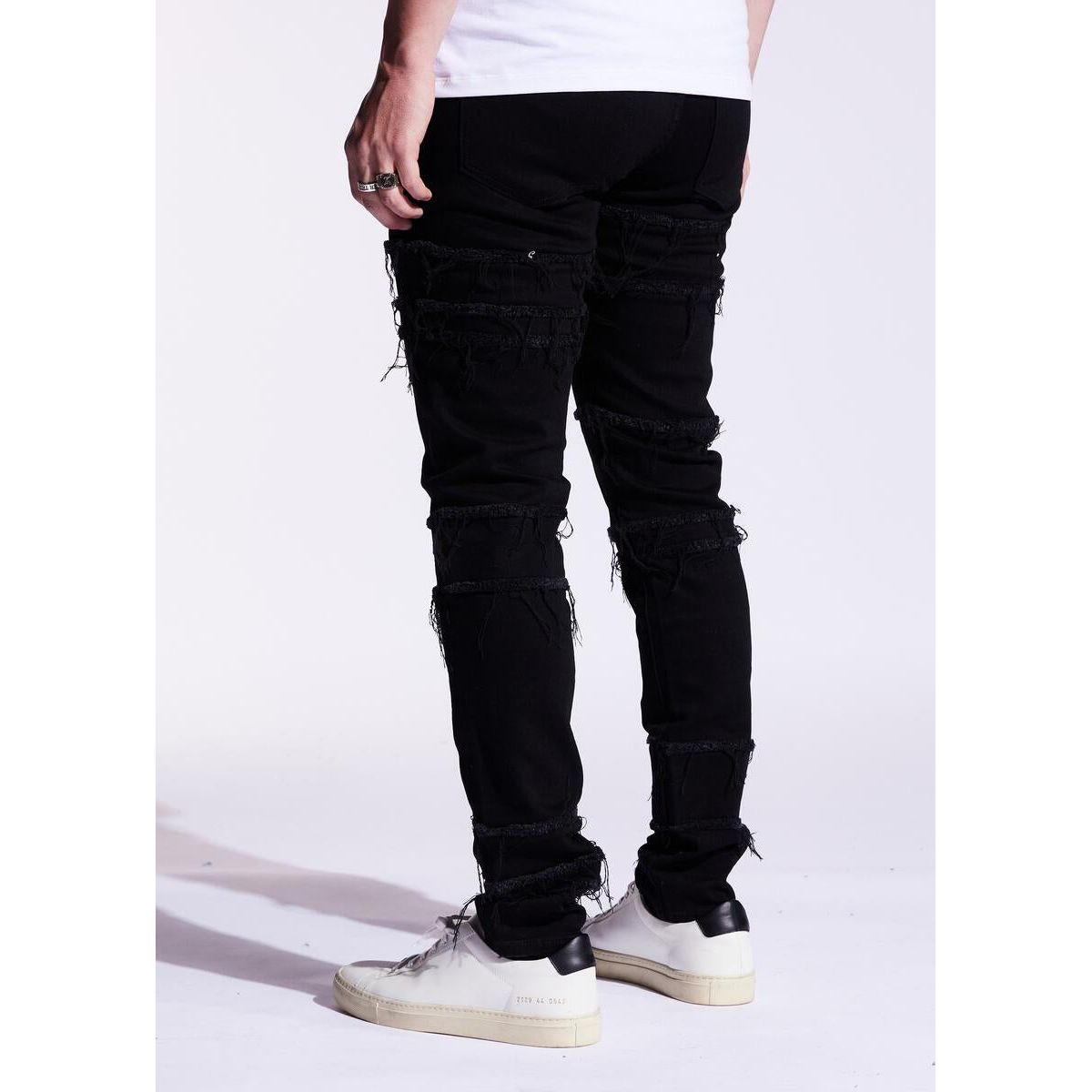High angle view of Embellish Black Distressed Blade Denim Jeans (EMBF221-111) laid flat on wooden surface