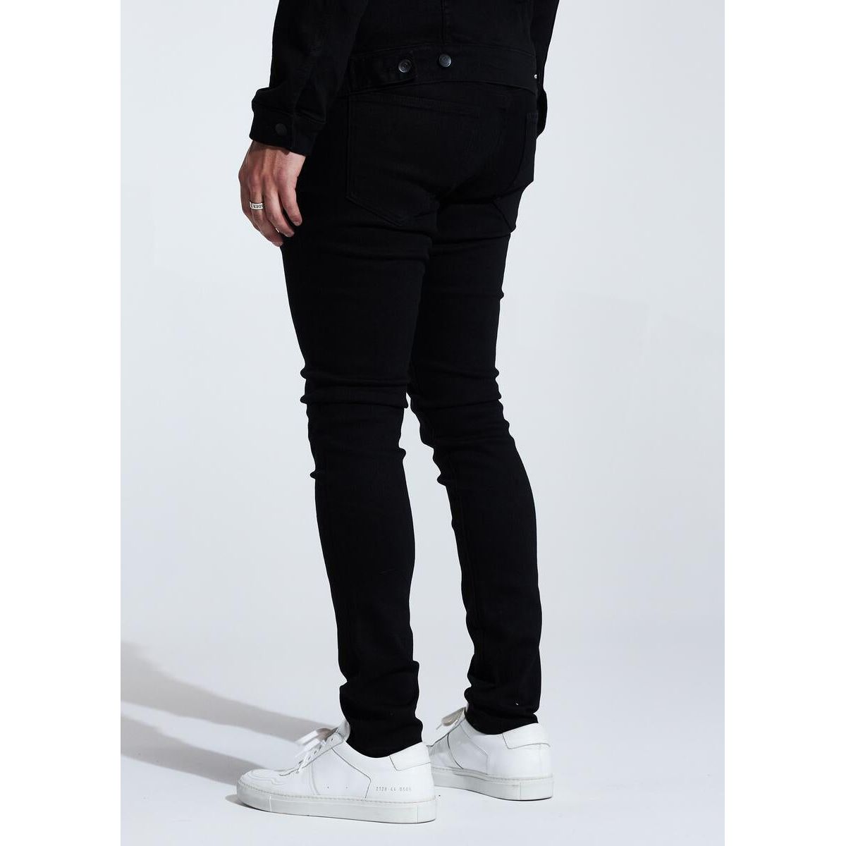 Embellish Spencer (No Distress) Jet Black Jeans back view, styled with sneakers