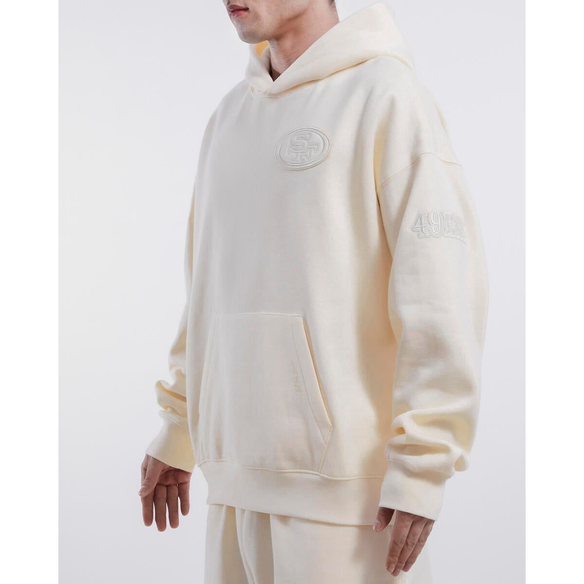 Pro Standard San Francisco 49ers Neutral Drop Shoulder Hoodie in Eggshell color, featuring the team logo and comfortable hood
