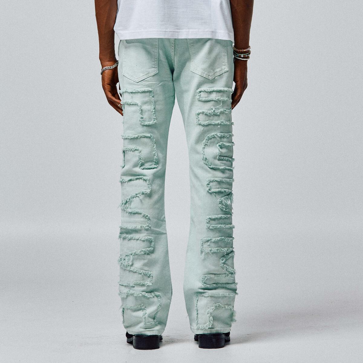 Person wearing Homme + Femme Twilight Green Denim Jeans with rolled-up cuffs