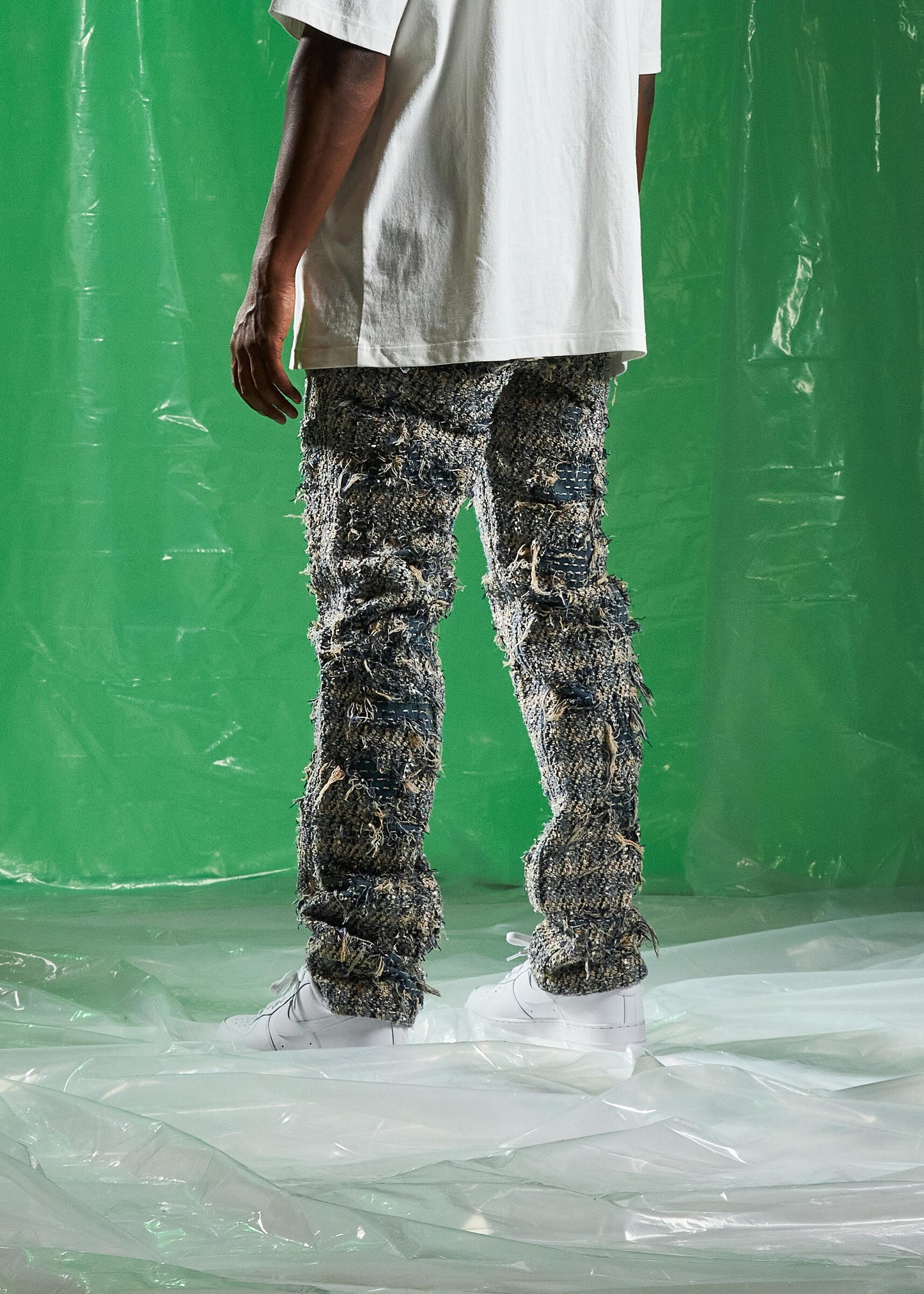 Side view of Embellish Blue Salvage Denim Jeans highlighting the frayed hem and vintage wash