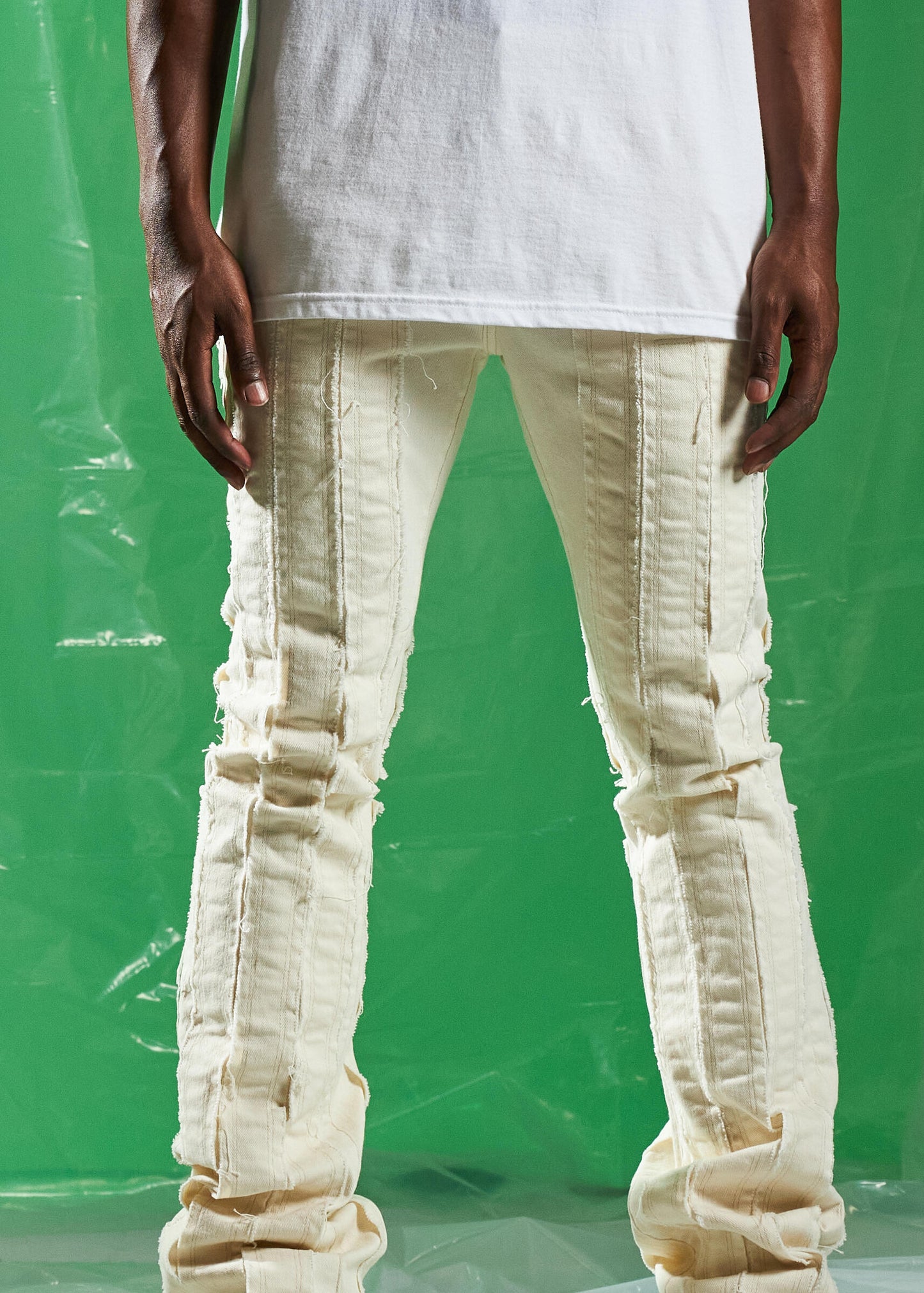 Embellish Ursus Cream Denim Jeans displayed on a clothing rack at a store