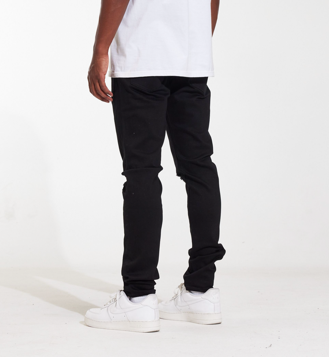 Close-up image of Crysp Denim Atlantic Black Ripped Denim Jeans, style CRYSPSUM24-036, showcasing distressed details and a slim fit design