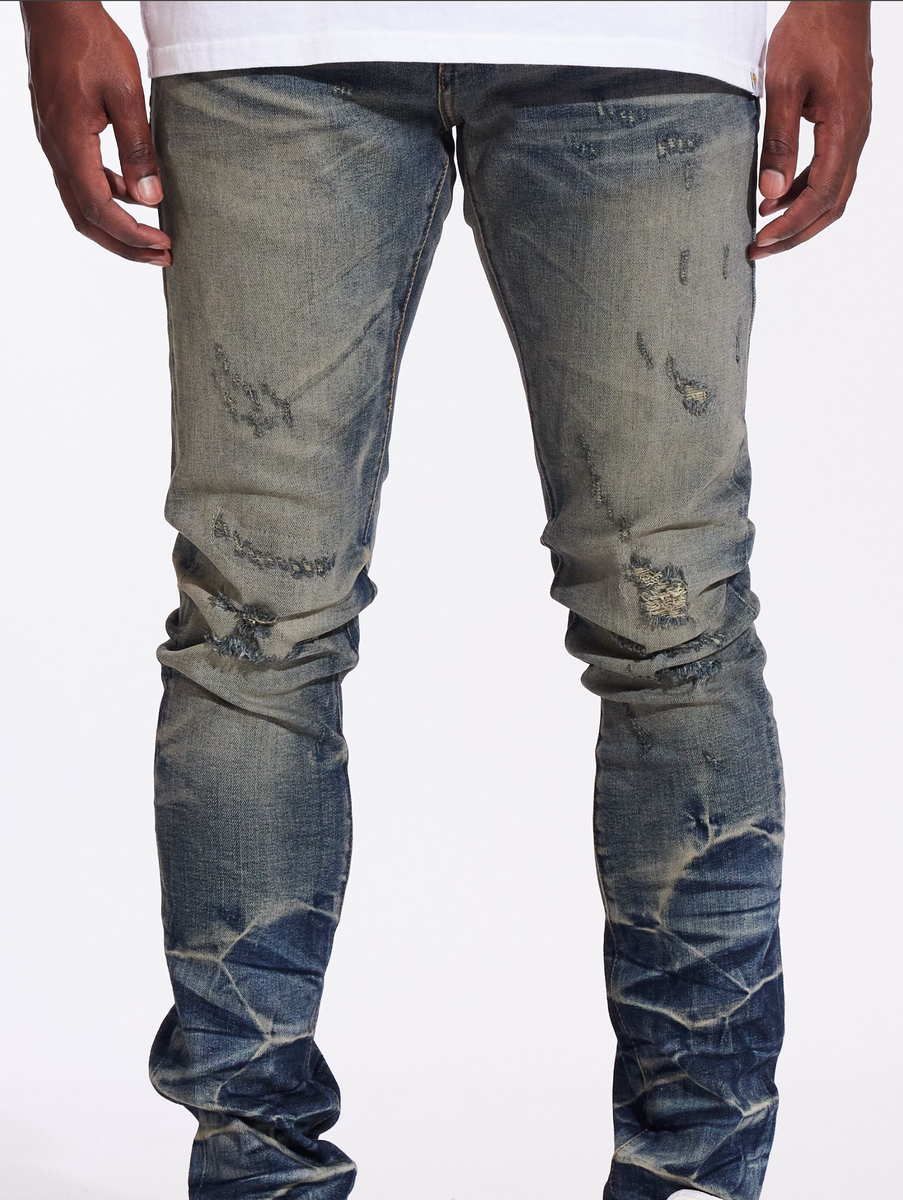 Crysp Denim Atlantic Dusty Indigo Denim Jeans (CRYF24-117) worn by a male model in urban setting with graffiti backdrop