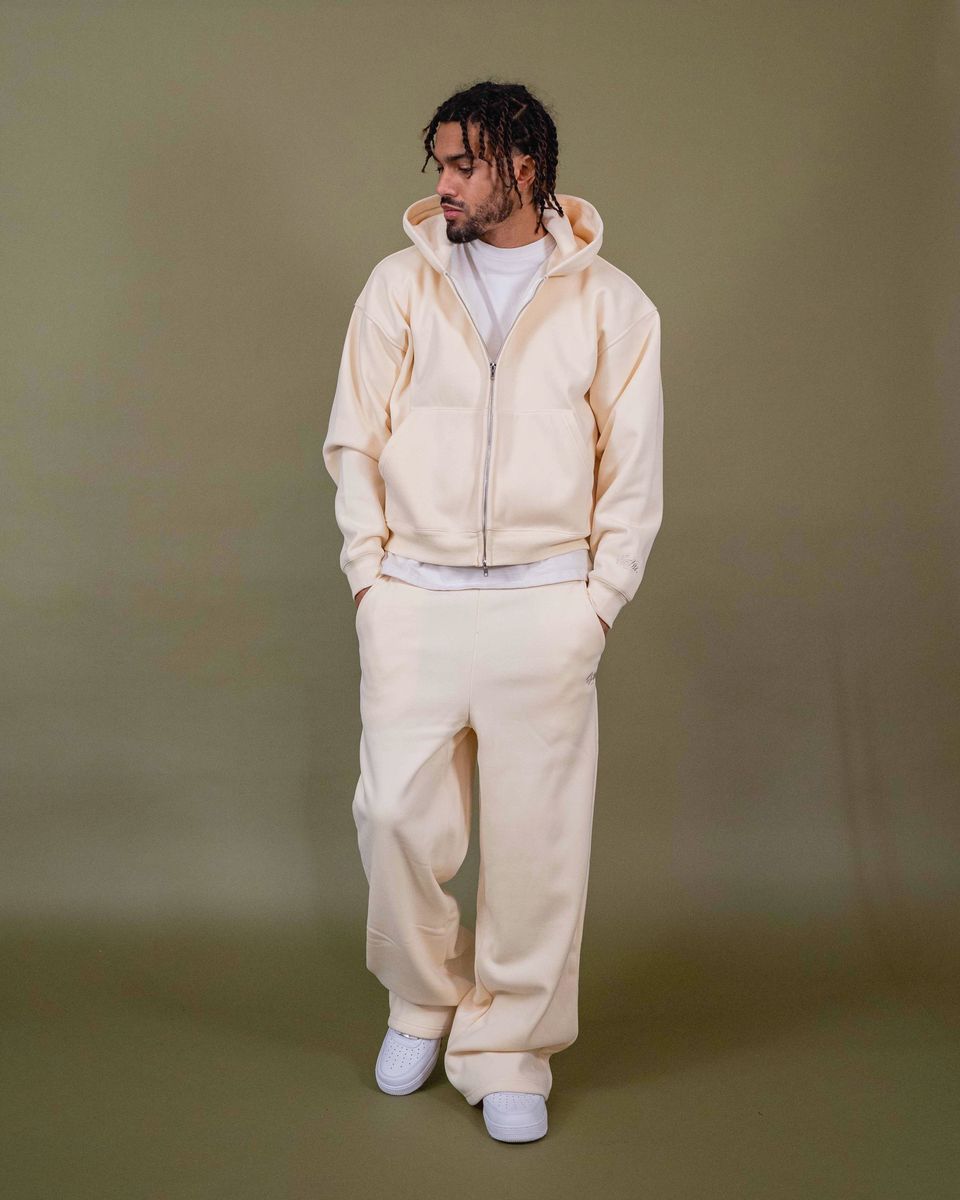 Baggy fit cream pants with logo embroidery and model wearing size M