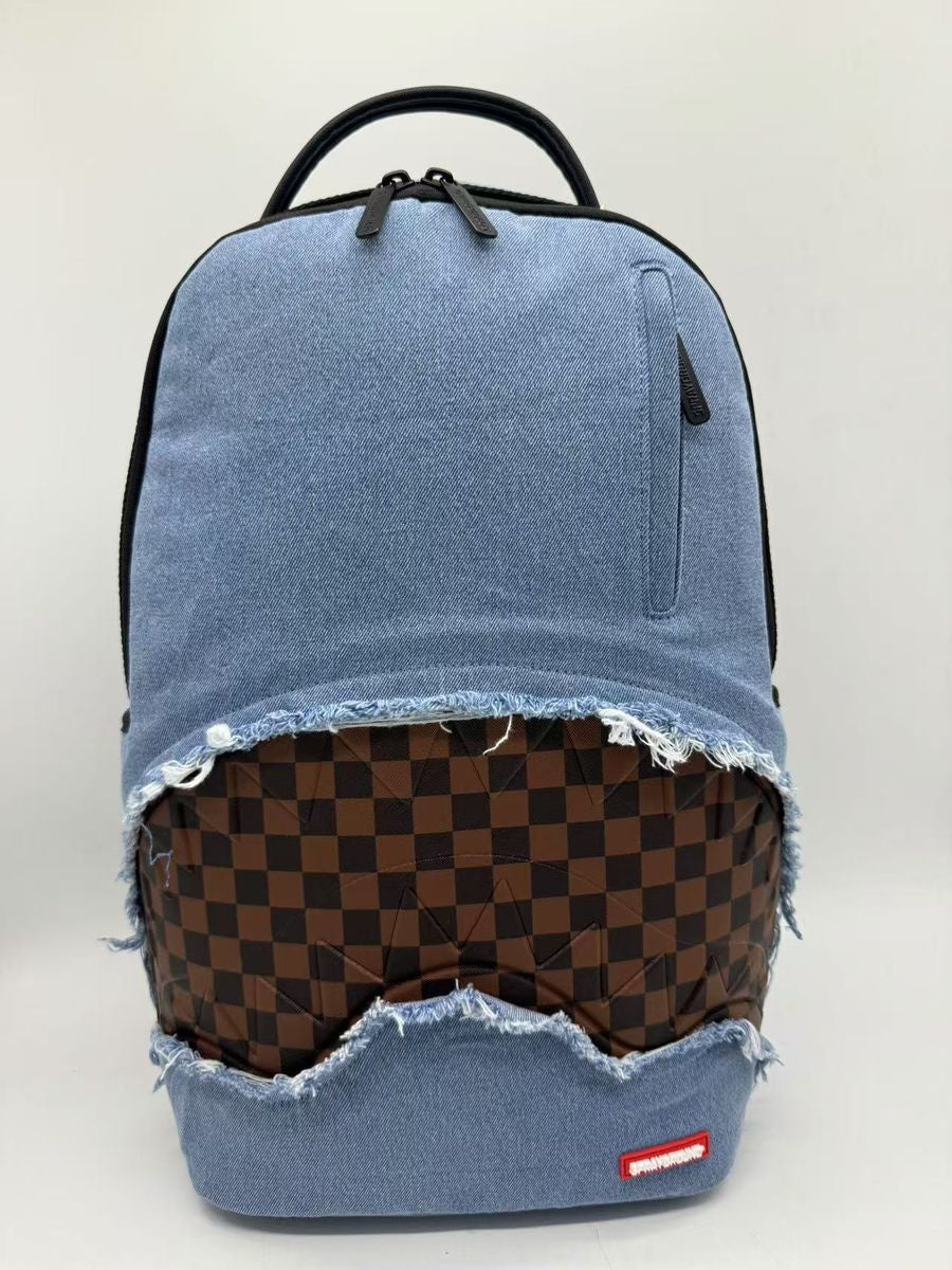 A stylish Sprayground Denim Shark Bite DLXSV Backpack made of 100% cotton denim twill, measuring 18 inches by 115 inches by 65 inches