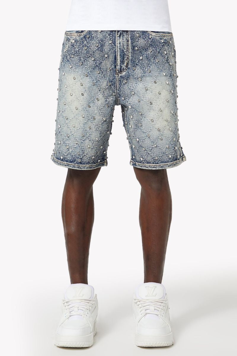 Close-up of shimmering rhinestone embellishments creating a sparkling diamond pattern on aqua blue denim shorts
