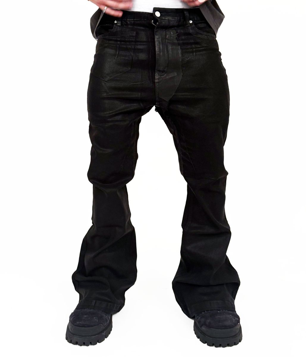 Model wearing oversized wideboy patchwork waxed denim jeans with flared silhouette in standing pose