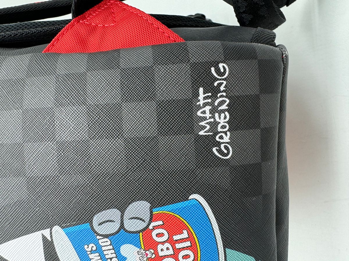 Close-up of the Sprayground Bender Fire Drama Backpack's durable PVC fabric with bold fire graphics and adjustable straps
