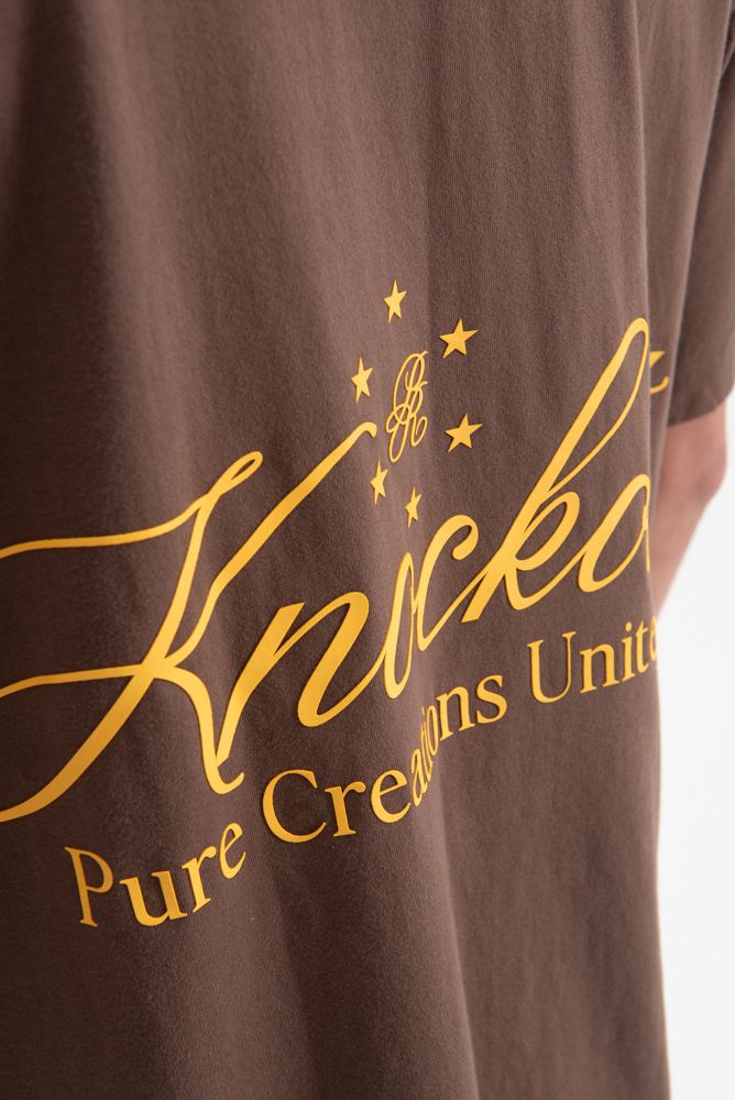 Zoomed-in of the stitching and hemming on the PURE Knockout Script Brown Tee