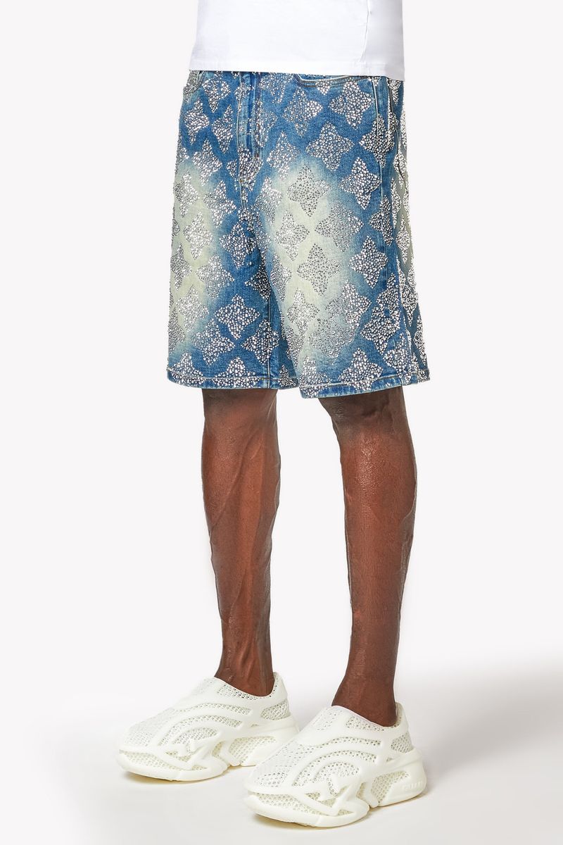 Close-up of embellished geometric design on vintage blue denim shorts showing detailed craftsmanship