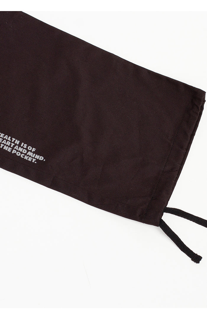 Close-up of the black cargo pants featuring the Billionaire Boy's Club logo patch and reinforced stitching