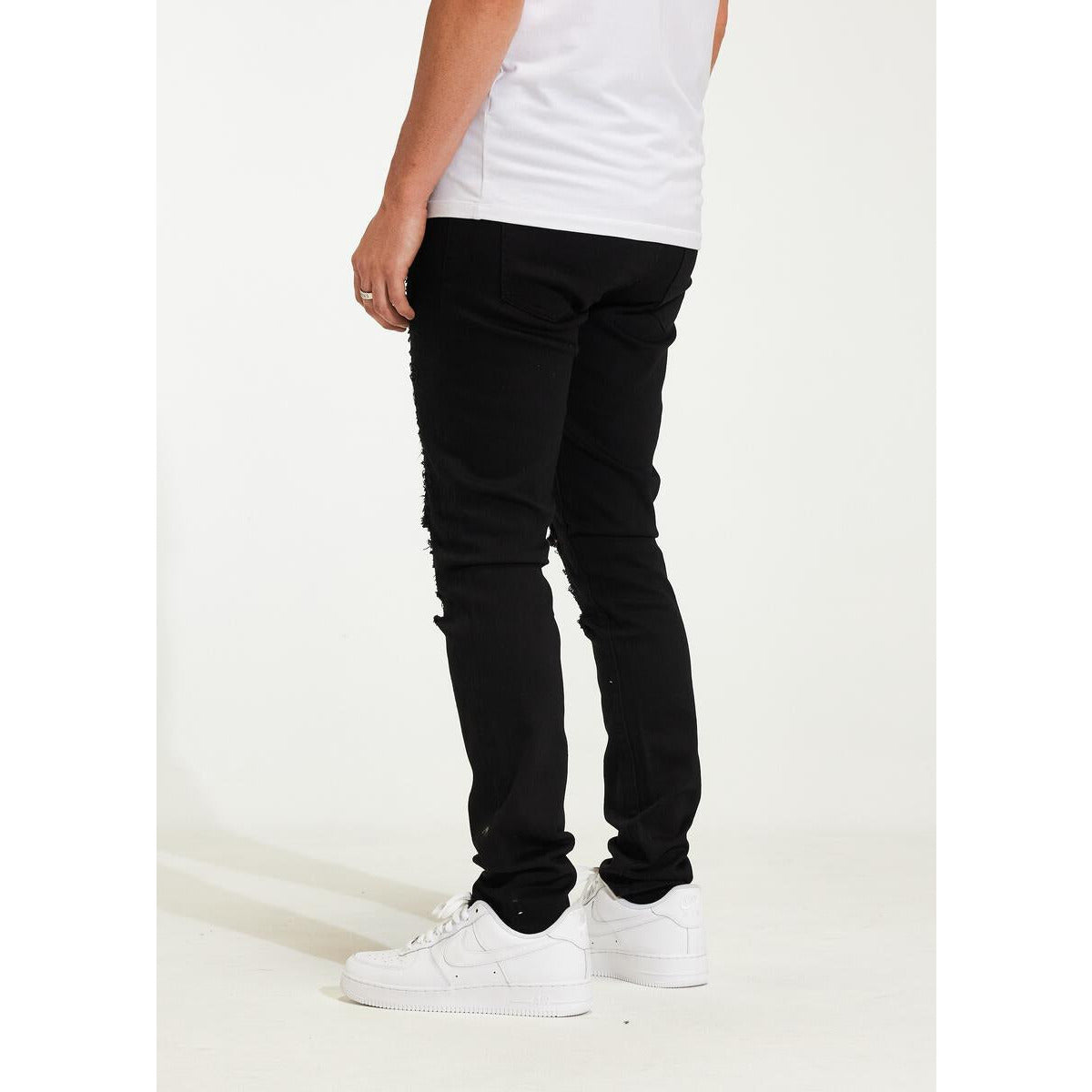 Cropped image of the bottom hem of Crysp Denim Atlantic Black Ripped Jeans (CRYH22-200) showcasing the frayed edges