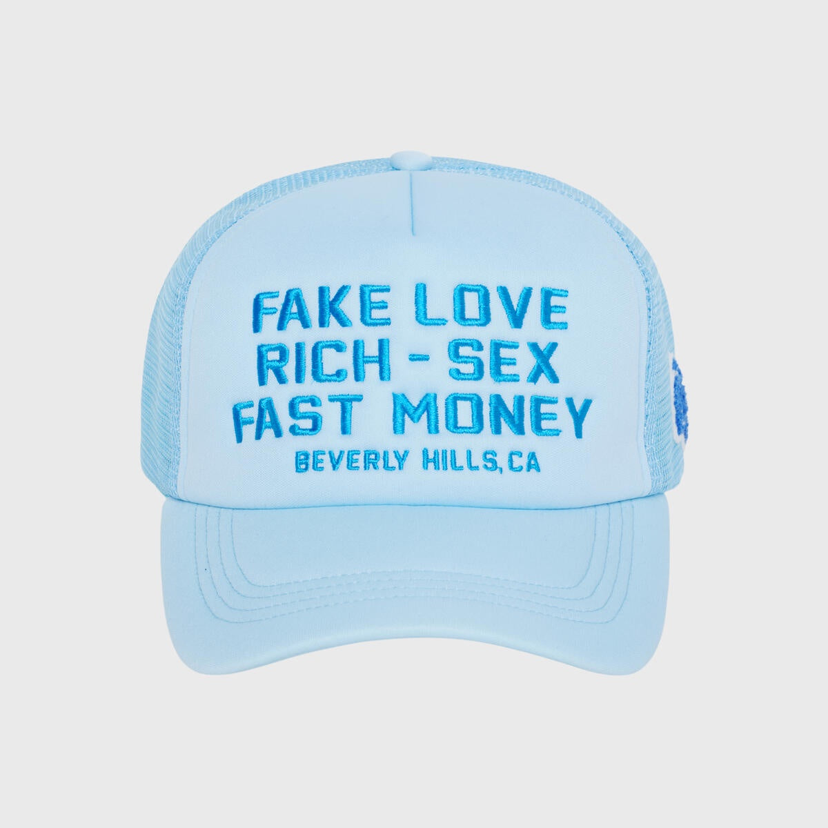 Baby blue classic trucker hat with Fake Love embroidery at front