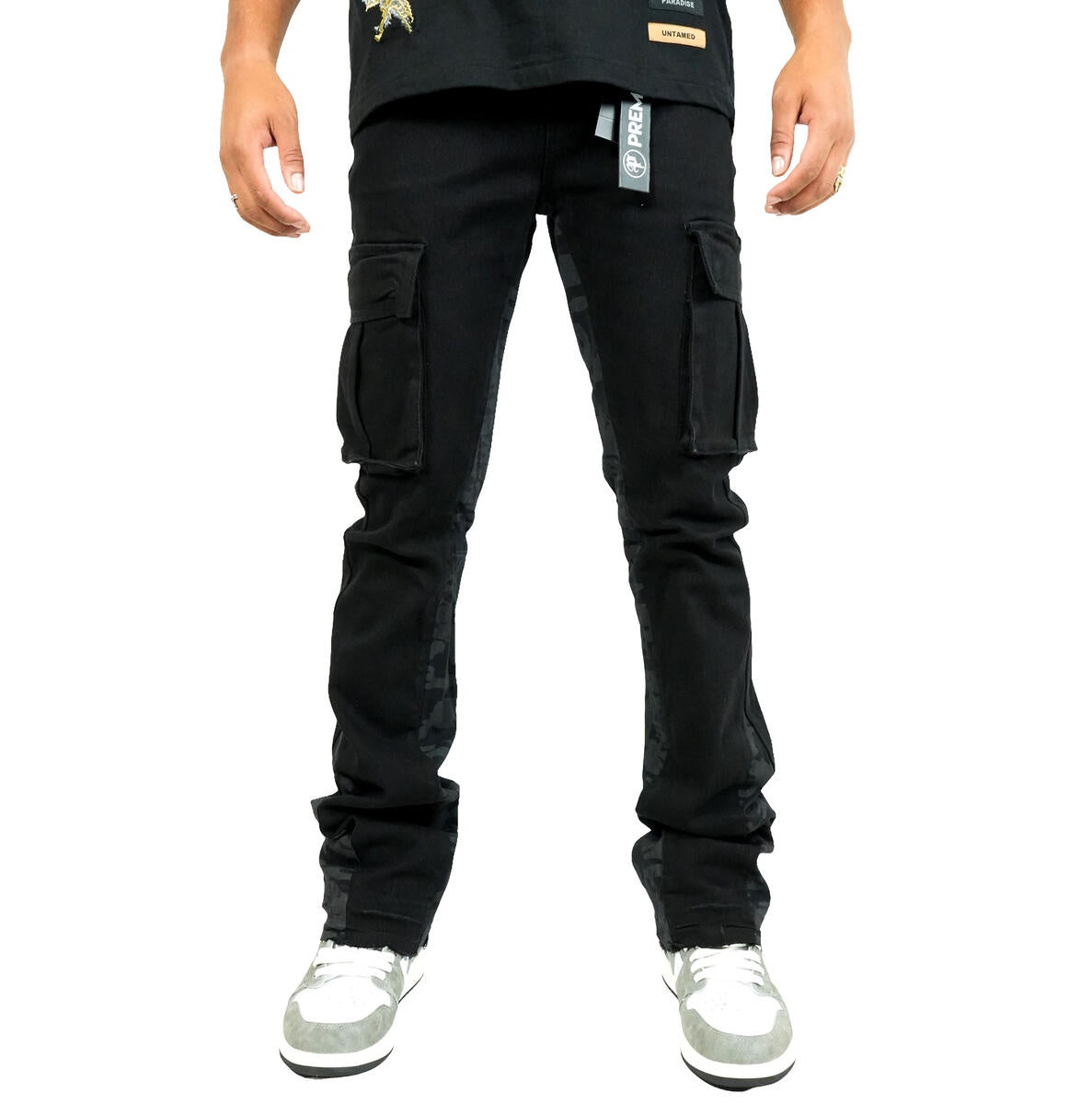 Close-up of Preme Black Canvas Camo Flare Denim jeans on model walking in urban setting, showcasing stylish and edgy design