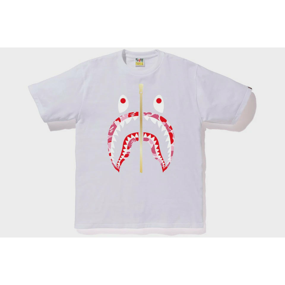 A close-up image of the BAPE ABC Gold Zip Shark Tee in white and pink, showcasing the gold zipper detail and iconic shark design