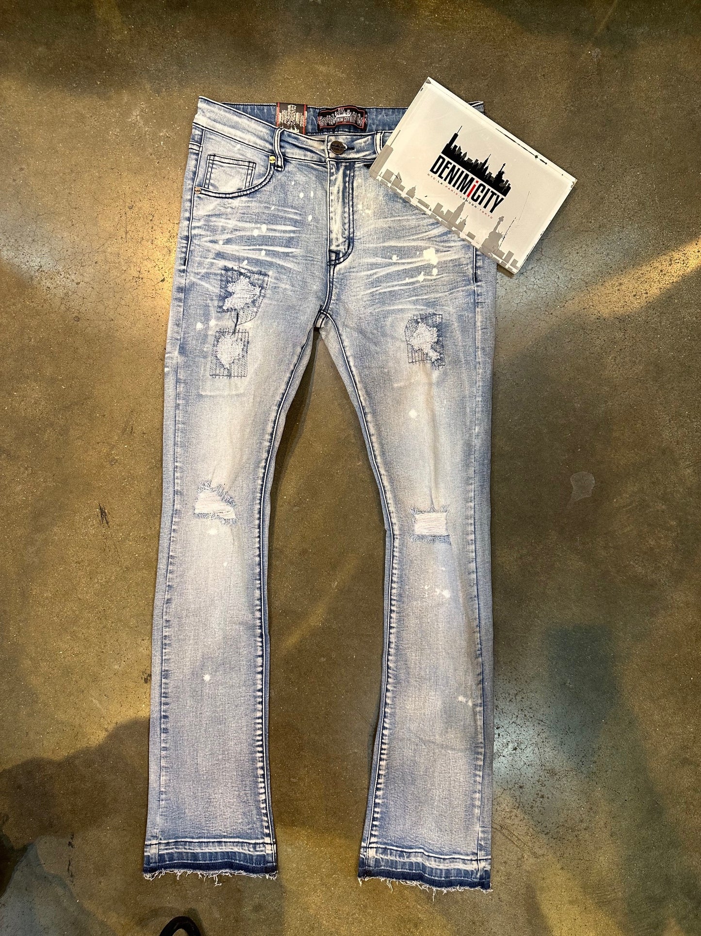 Close up of DENIMiCITY Knee Rip Bleached Light Blue Stacked Denim jeans with distressed detailing and faded wash