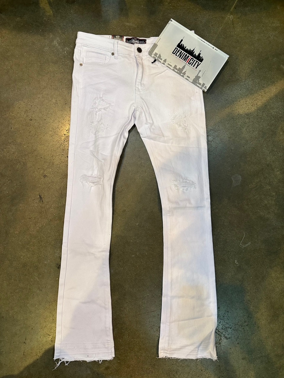 Close-up of DENIMiCITY Knee Rip White Stacked Denim jeans with stylish knee rip detail