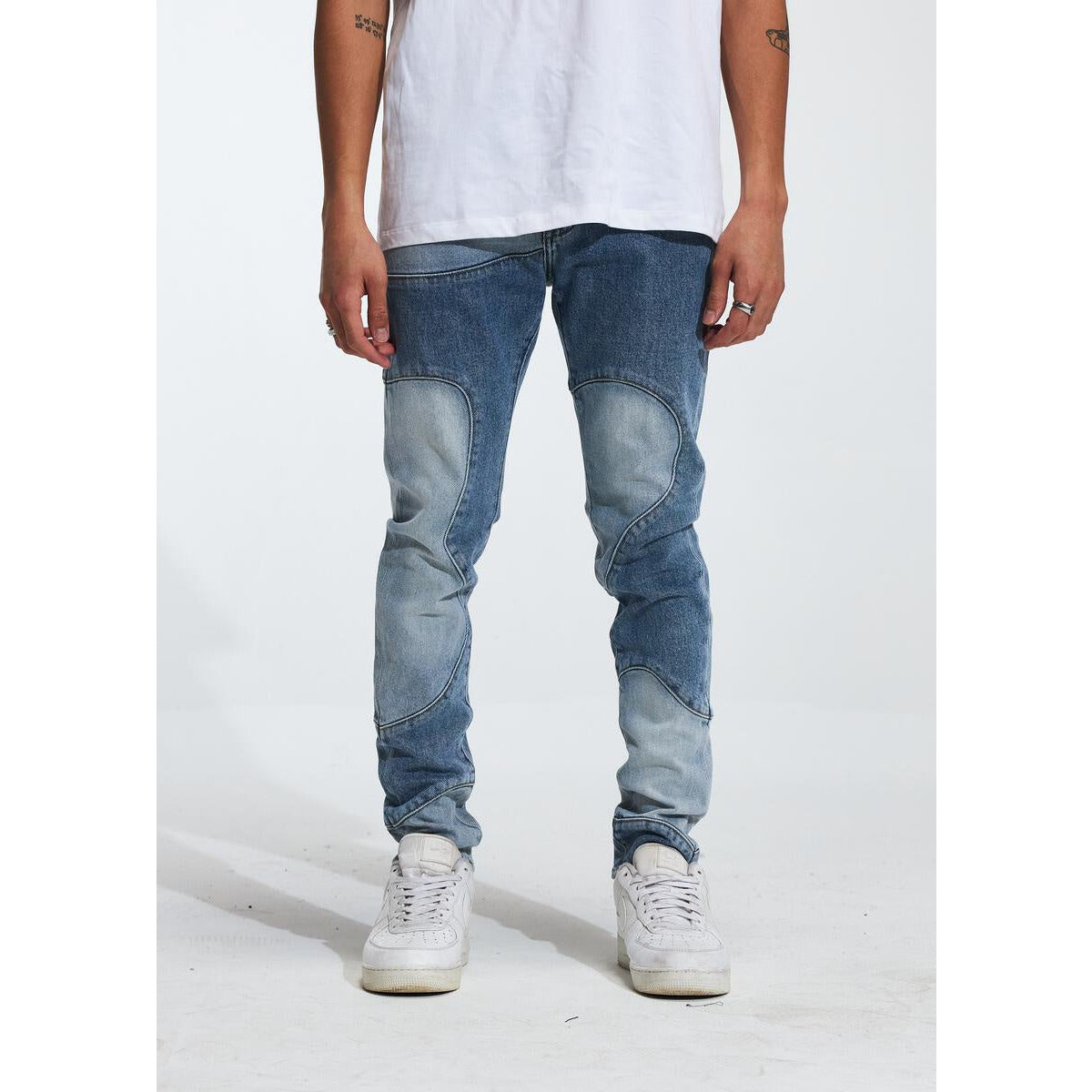 Crysp Denim Topo Blue Jeans (CRYF222-204) resting on a wooden table in a well-lit room, showcasing its distressed design and classic five-pocket style