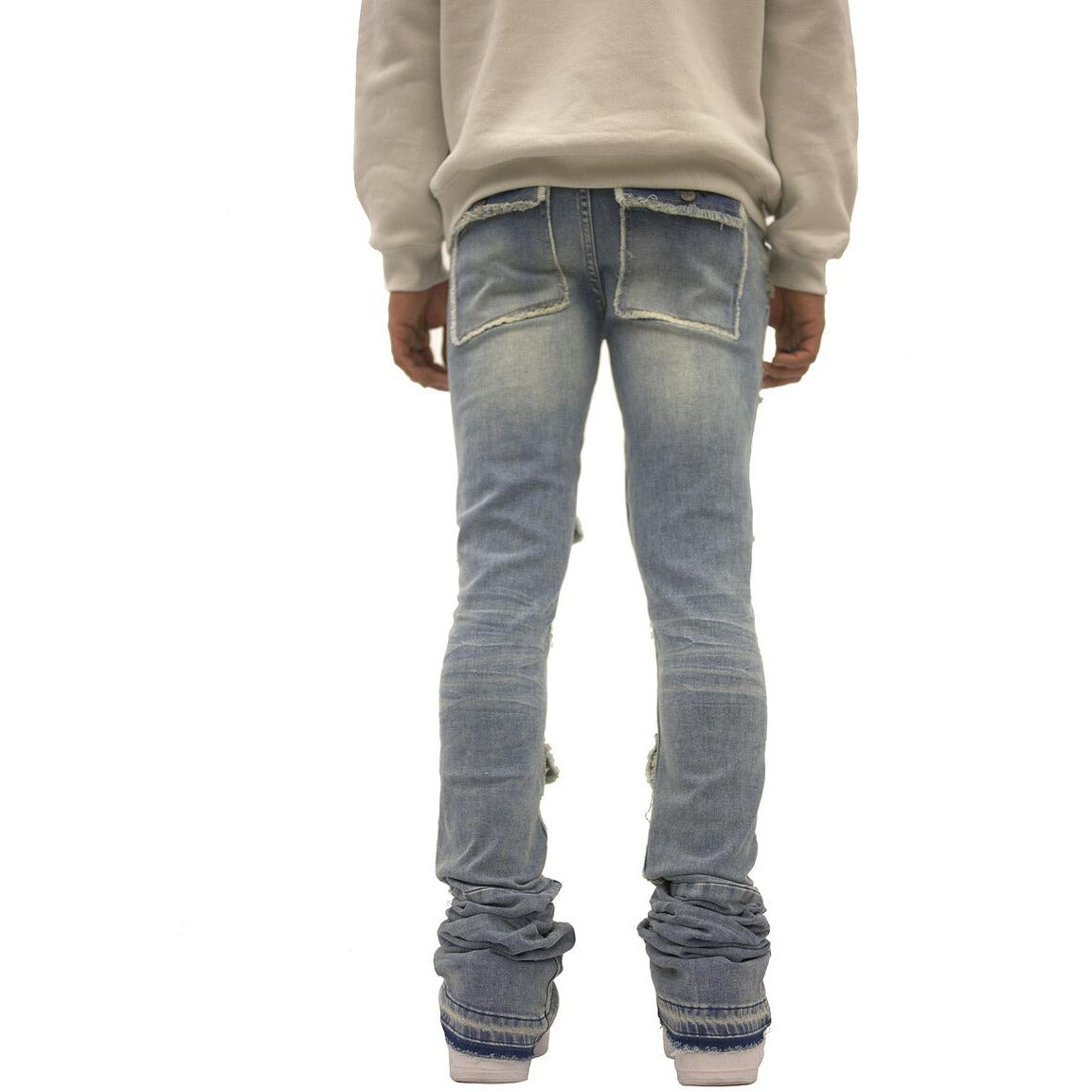 Model wearing Doctrine Savant Stacked Jeans - Medium Indigo Wash, side view