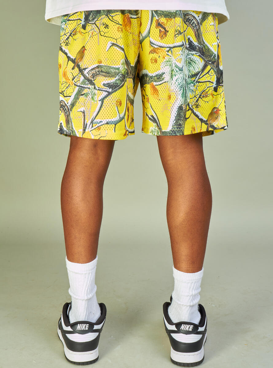 Yellow mesh shorts with 'Politics Branches' design, perfect for casual wear