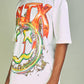 White and orange graphic tee with 'Politics PLTX' design, perfect for political enthusiasts