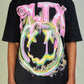 Close-up of black and pink Politics PLTX Graphic Tee on a hanger