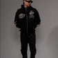 High-quality close-up of black denim fabric and rhinestone embellishments