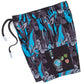 Front view of Cookies Corsica Black Swim Shorts on a wooden deck against a tropical backdrop, showcasing the sleek and stylish design with a comfortable fit for all-day wear