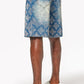 Model wearing vintage-inspired blue embellished denim shorts with relaxed fit and shine details