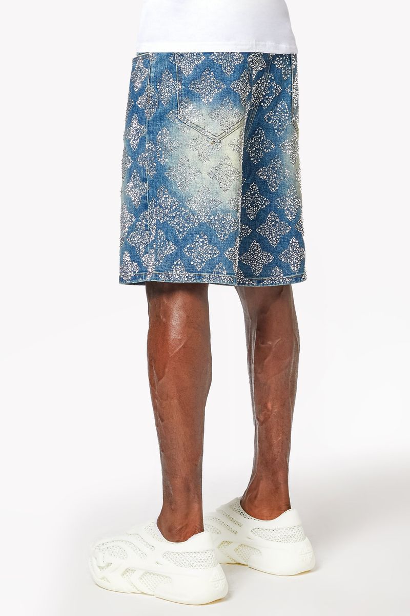 Model wearing vintage-inspired blue embellished denim shorts with relaxed fit and shine details