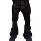 Model wearing oversized wideboy patchwork waxed denim jeans with flared silhouette in standing pose