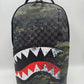 Front view of the Sprayground Camo Splash DLXSV Backpack showcasing its spacious dimensions of 18 by 115 inches with sturdy construction