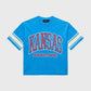 A cropped blue T-shirt featuring varsity stripe sleeves, bold KANSAS print on the chest, Homme Femme logo below, stone washed vintage look, heavyweight cotton, perfect for Spring 2025 collection