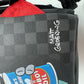 Close-up of the Sprayground Bender Fire Drama Backpack's durable PVC fabric with bold fire graphics and adjustable straps