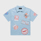 Premium men's and women's Road Trip Baby Blue Button Down featuring digitally printed logos and mother of pearl buttons