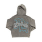 Close-up of the grey Rhinestone Cupid design on the zip-up hoodie with intricate detailing