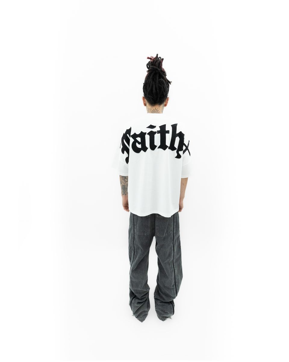 Labeled image of the Faith+Figures Faith+ Jumbo short sleeve tee displaying the product tag and material information