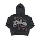 Close-up of the Mixed Emotion Cupid design with rhinestones on the acid wash black hoodie