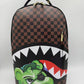 Front view of the Sprayground Money Grump DLXSV Backpack highlighting its 18-inch height, 115-inch width, and 65-inch depth constructed from durable 100% PVC material