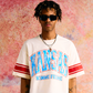 Spring 2025 collection cropped off white tee with Kansas print, varsity sleeve stripes, and a vintage stone wash finish