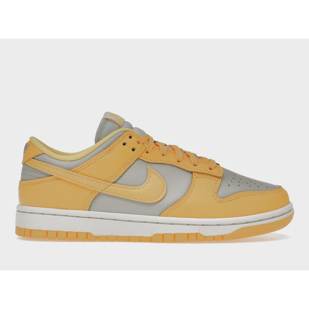 Close-up image of the Nike Dunk Low Citron Pulse women's shoe, featuring a vibrant yellow and green colorway with Nike branding on the tongue and heel, perfect for stylish and sporty casual wear